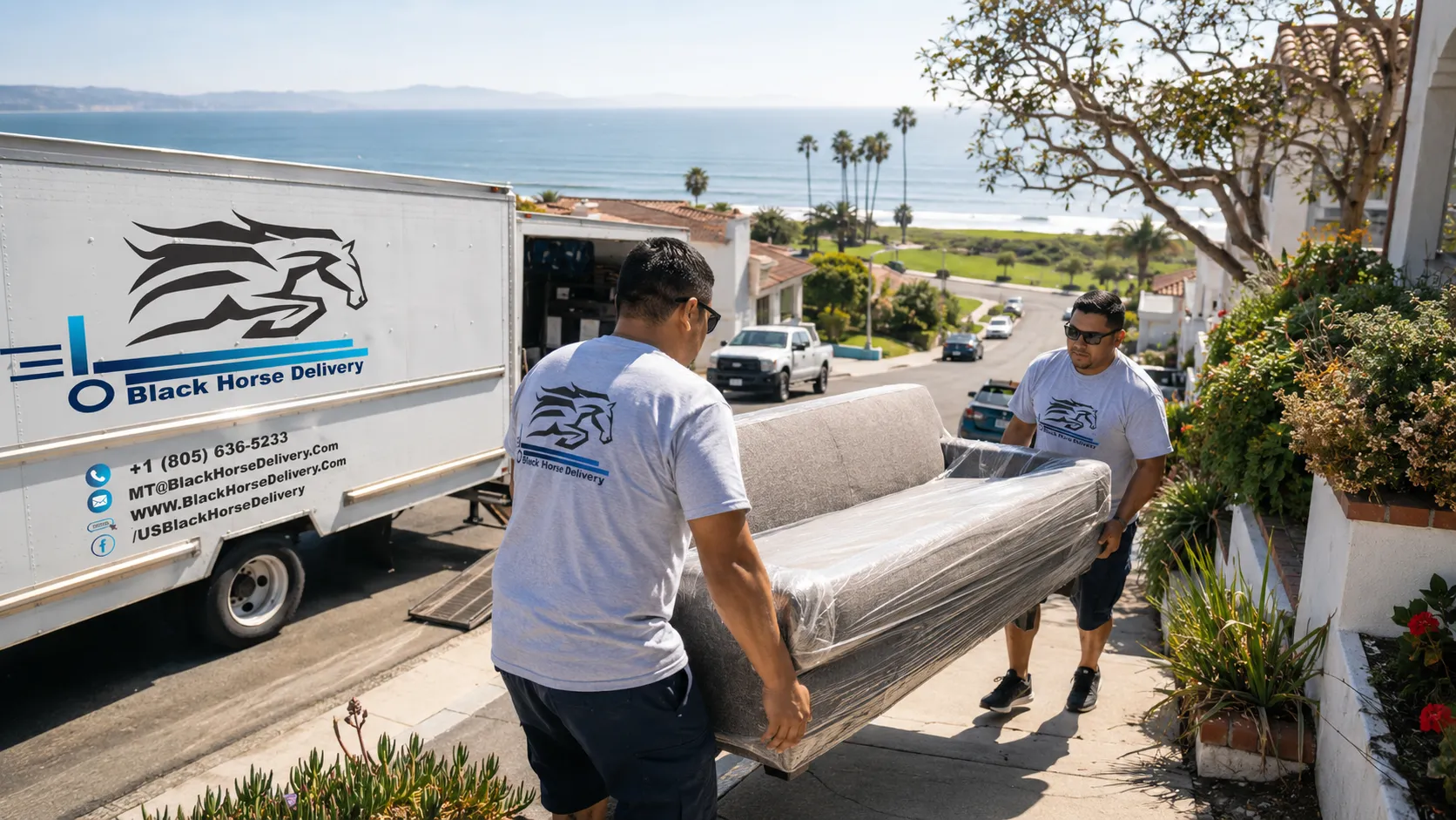 Movers carrying a sofa up a steep, narrow Mesa street near Shoreline Park