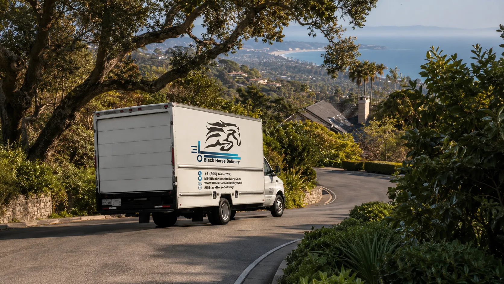 A moving truck navigating a narrow, winding hillside road in Montecito